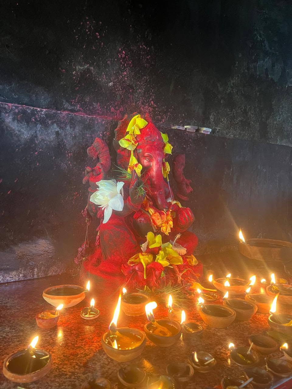 Statue de Ganesh entourée de lampes traditionnelles