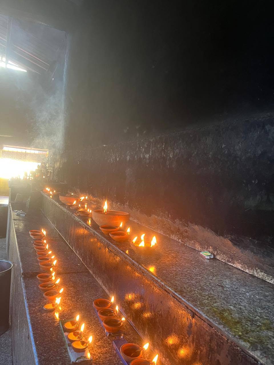 Lampes traditionnelles allumées dans un temple en Inde